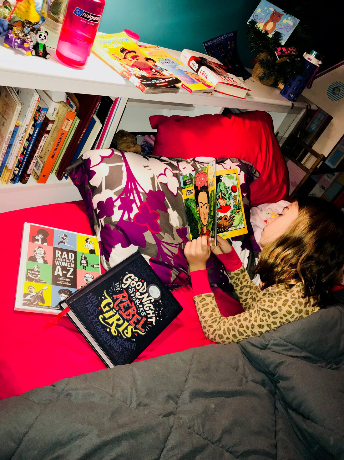 image of a child reading a book in bed